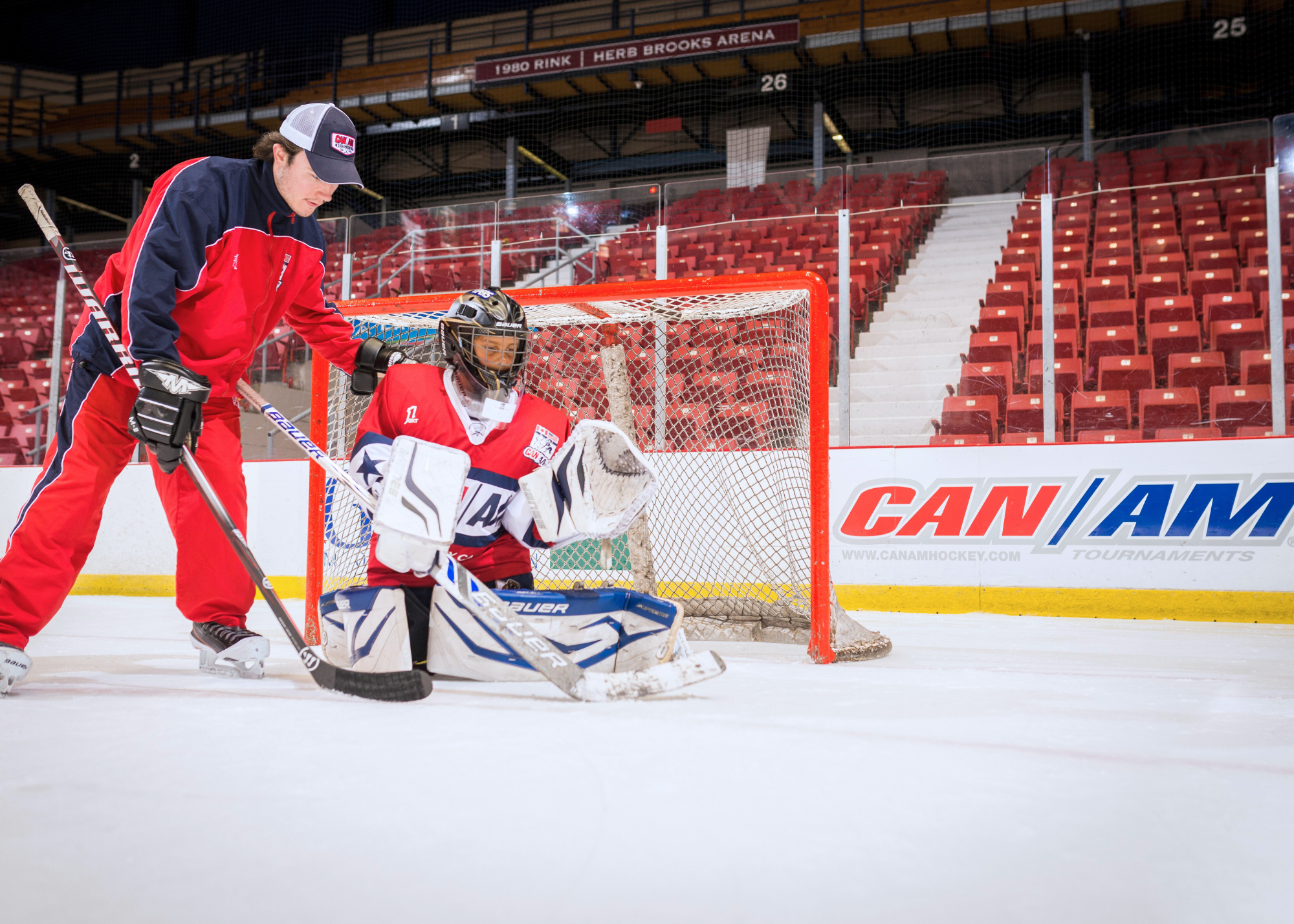 Coach with goalie in front of net Coach with goalie in front of net